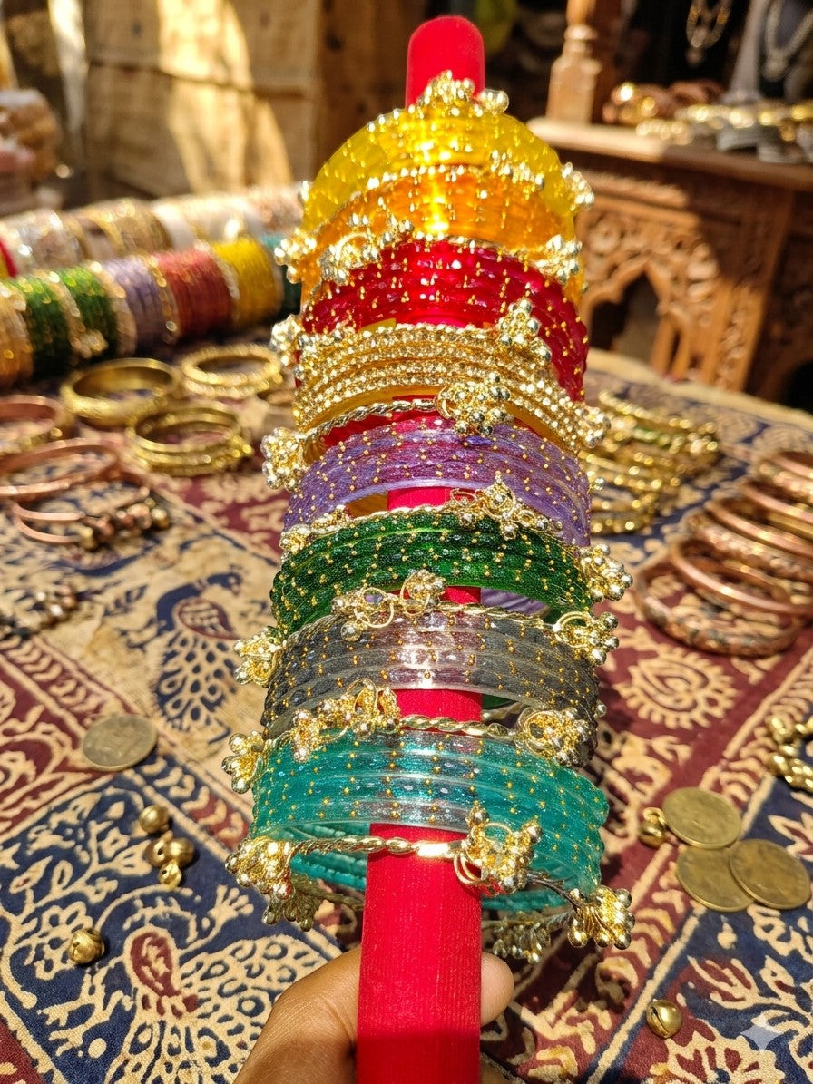 Libasaa.com set of 8 colorful glass bangles with ghungroo bells and gold raindrop design. Traditional Indian bridal jewellery.