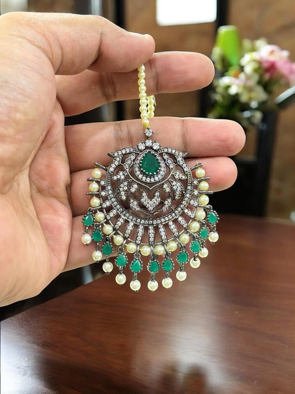 Green & gold-plated kundan maang tikka with pearls, ideal for bridal and festive wear